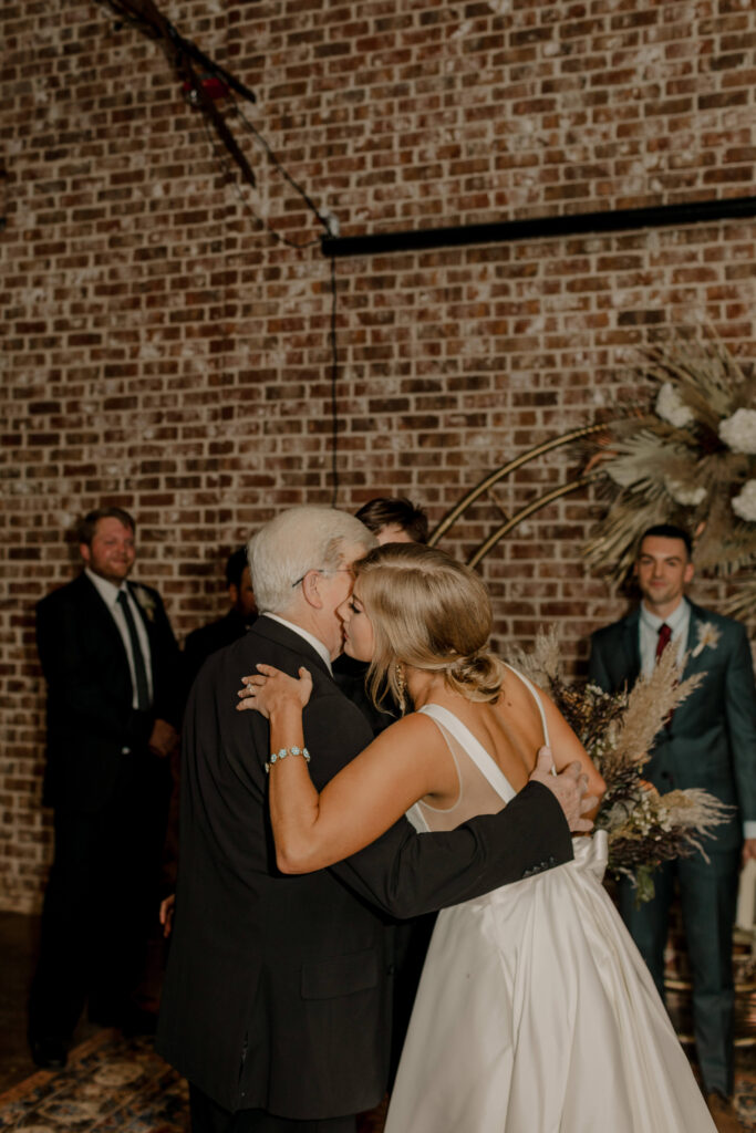 bride hugging family at wedding reception